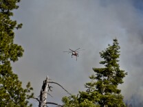 A helicopter flies over the Lake Fire Thursday afternoon off Jenks Lake Road in the San Bernardino National Forest. 