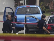 This Feb. 7, 2013 file photo law enforcement officers look over the scene of an officer involved shooting in Torrance, Calif.