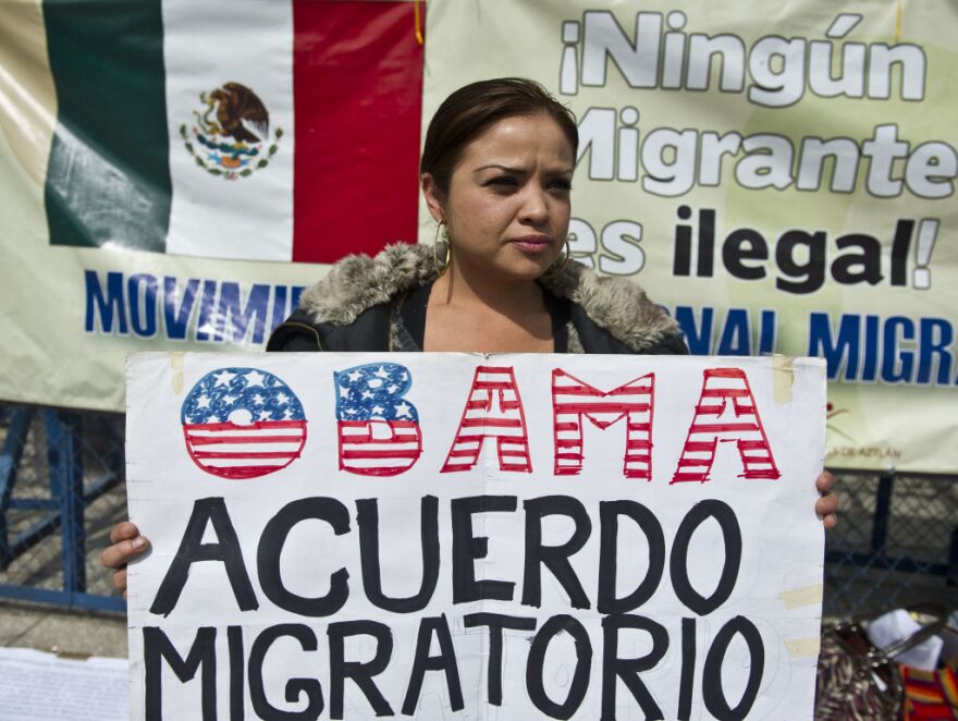 A Mexican member of migrants organizations holds a sign during a protest in front of the US embassy against the trafficking of weapons to Mexico and the failure of the US immigration reform, on January 21, 2013, in Mexico City.