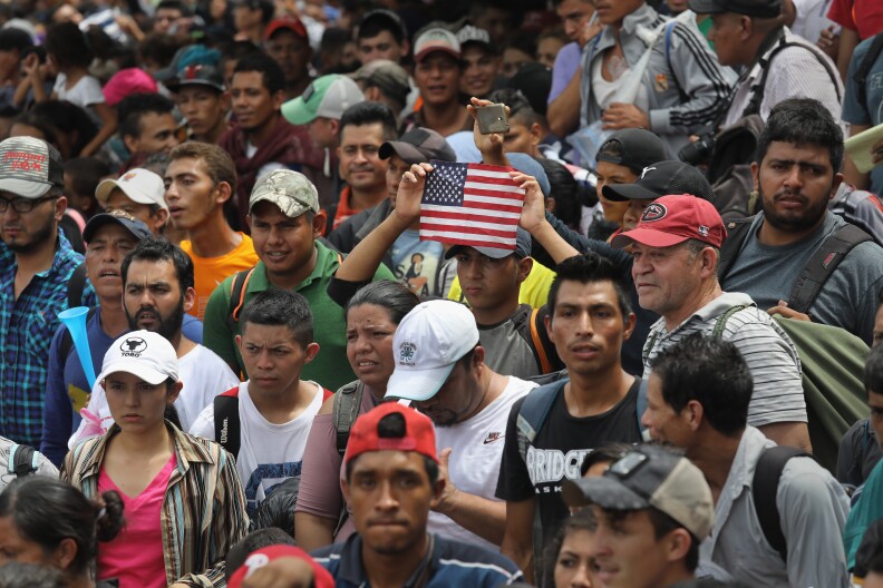 CIUDAD TECUN UMAN, GUATEMALA - OCTOBER 19:  Members of the migrant caravan push forward at a gate separating Guatemala from Mexico on October 19, 2018 in Ciudad Tecun Uman, Guatemala. The caravan of thousands of immigrants, most from Honduras, pushed open the gate on the Guatemalan side and crossed the bridge to Mexico but were then pushed back by Mexican riot police.  (Photo by John Moore/Getty Images)