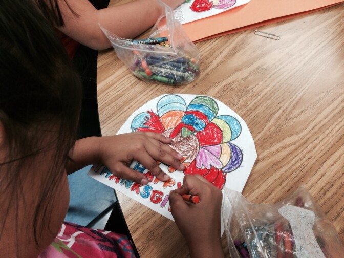 Kindergarten student colors a picture for her Thanks Giving book cover at Weemes Elementary school in Exposition Park. 