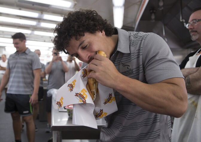 PHILADELPHIA, PA - SEPTEMBER 14: Juan Pablo Socino of the Newcastle Falcons takes a bite of his cheesesteak at Geno's Steaks on September 14, 2017 in Philadelphia, Pennsylvania. (Photo by Mitchell Leff/Getty Images)
