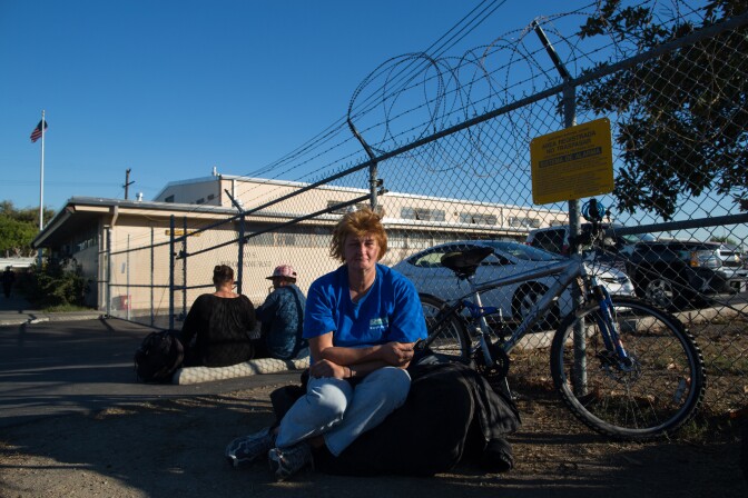 Kristen Konig sits in front of the Fullerton Armory, which offers housing for the homeless population in Orange County during the holiday season. Konig is originally from Orange County and has been in and out of shelters for the past seven years.