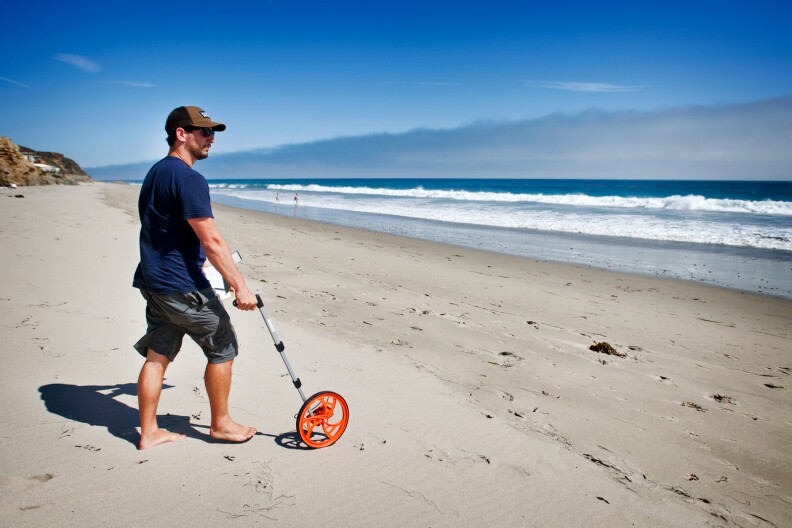 Nick Schooler, a UCSB graduate student in marine science, takes down tide measurements of a Malibu beach on July 24. Once a month, UCSB researchers spend three days tracking the crustaceans in the area.