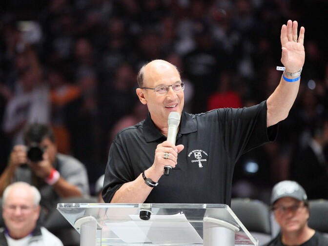 File: Los Angeles Kings play-by-play television announcer Bob Miller addresses the fans as General Manager Dean Lombardi (bottom right) and Assistant to the General Manager Jack Ferreira (bottom left) look on during the rally in Staples Center after the Los Angeles Kings Stanley Cup Victory Parade on June 14, 2012.