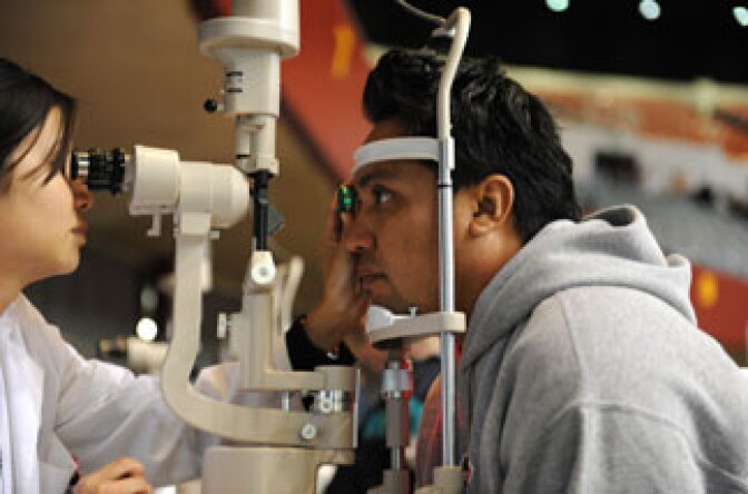 Domingo Andrade (R) gets an eye exam at a free clinic sponsored by Remote Area Medical (RAM), a Tennessee-based nonprofit, in Los Angeles on April 28, 2010.