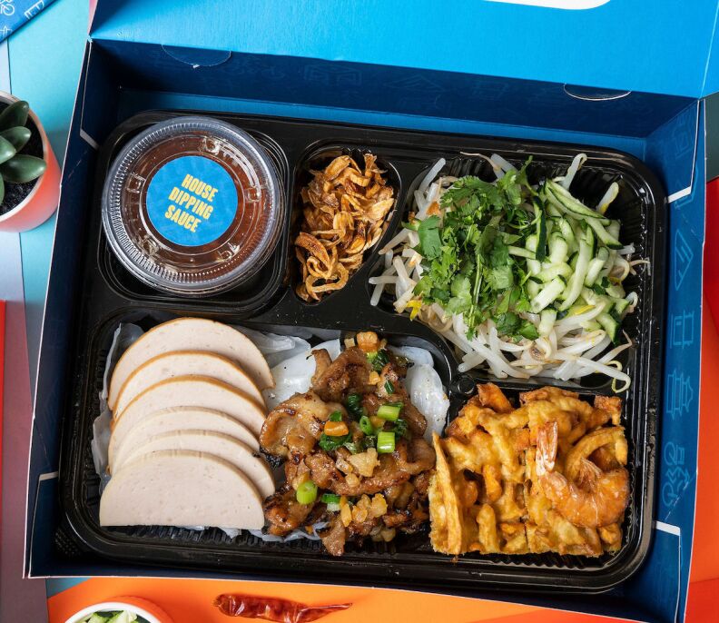 Tay Ho Vietnamese food to-go box with various items and dipping sauce.