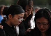USC students stand in silence outside the Shrine Auditorium following a memorial service April 18, 2012, for Ying Wu and Ming Qu, a pair of foreign students studying engineering who were fatally shot last week as they sat in a parked car near campus. USC and LAPD officials announced new campus safety measures Thursday morning.