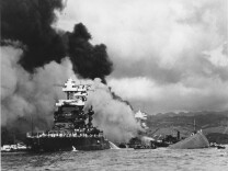 File: in this Dec. 7, 1941 file photo, the battleship USS West Virginia, center, begins to sink after suffering heavy damage, while the USS Maryland, left, is still afloat in Pearl Harbor, Oahu, Hawaii. The capsized USS Oklahoma is at right.
