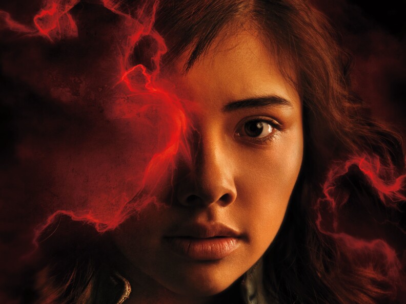 A close up of a woman's face, partially obscured by red smoke