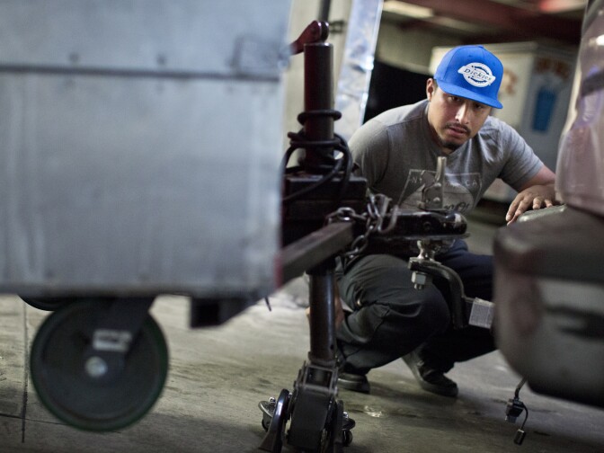 Cesar Emilio loads a "G&E Grill" food cart onto his pickup truck on Wednesday morning, Sept. 2, 2015 at Kareem Cart Commissary and Manufacturing Co. in South Los Angeles. Emilio will take the cart to a Home Depot in Huntington Park for the day.