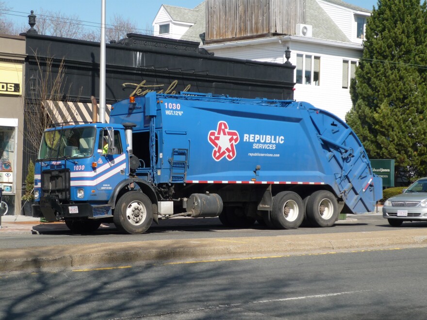 A blue garbage truck with a red star logo on a street. Beside the logo is the text "Republic Services."