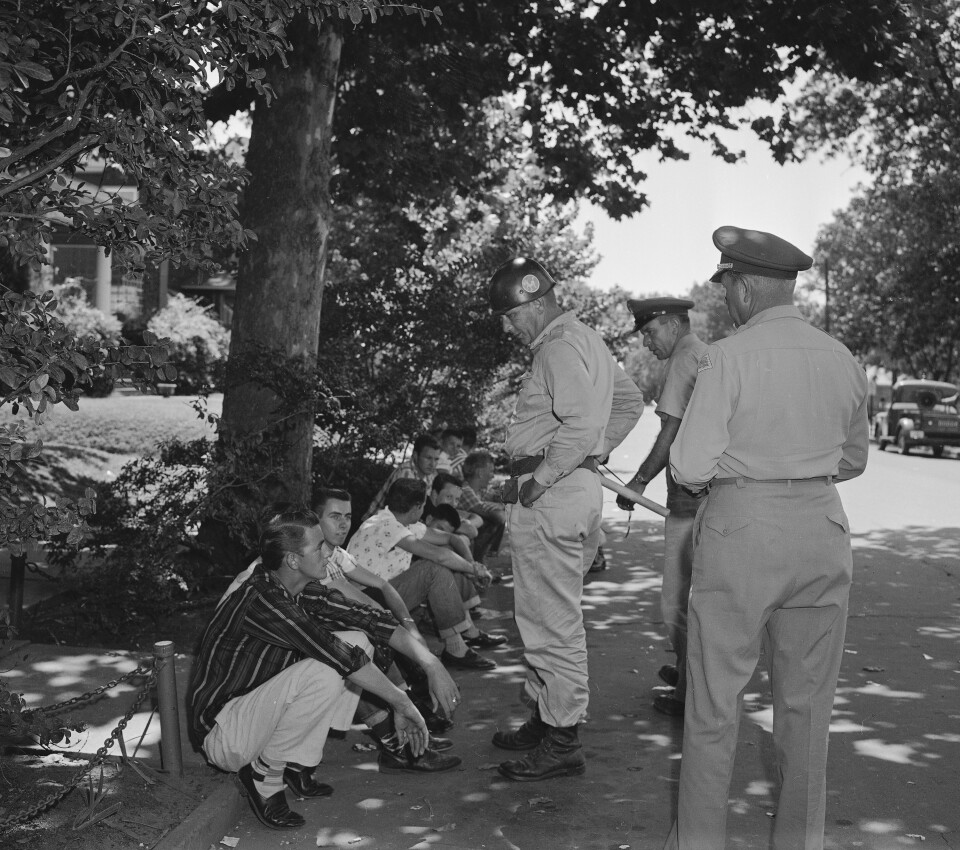 FILE - In this Sept. 5, 1957 file photo, teenagers who heckled passersby at Central High School in Little Rock, Ark., are held by National Guardsmen and told to either quiet down or be escorted from the scene. Five decades and $1 billion after an infamous racial episode made Little Rock a symbol of school segregation, the legal fight to ensure all of its children receive equal access to education has ended. (AP Photo/William P. Straeter, File)