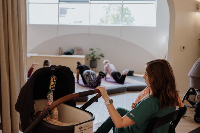 While parents participate in a movement class, postpartum doulas care for their newborn babies.