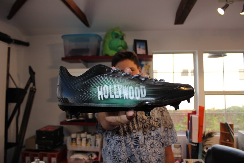Wes Burton shows off one of his recent custom cleat creations.