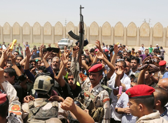 Iraqi Army soldiers and volunteers chant slogans against the al-Qaida inspired group Islamic State of Iraq and the Levant (ISIS), inside of the main army recruiting center in Baghdad on Saturday.