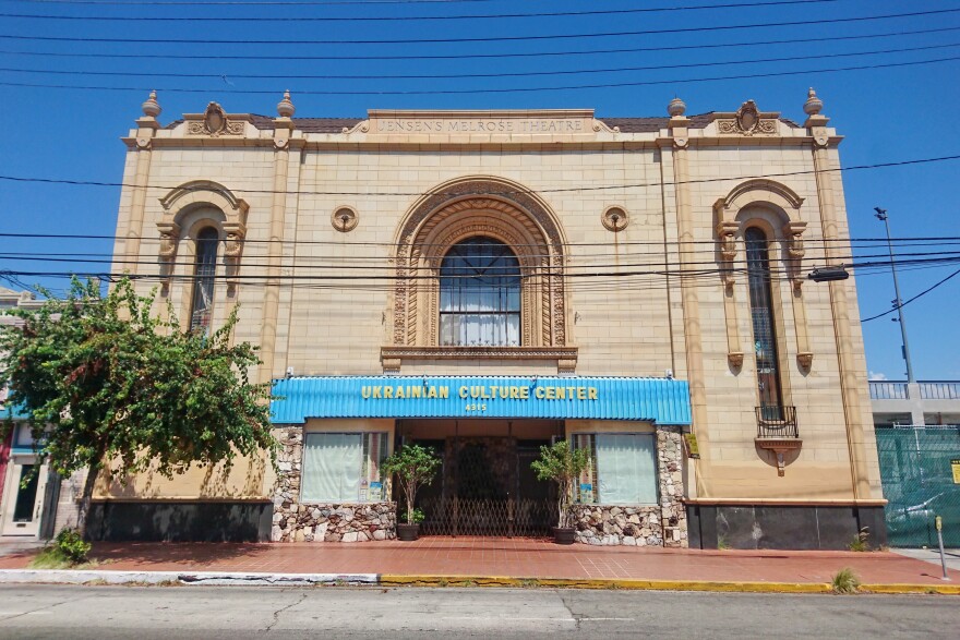 The Ukrainian Culture Center in East Hollywood is seen from the street. The front is made of tan stone and the sign is blue with yellow letters that read 'Ukrainian Cultural Center'