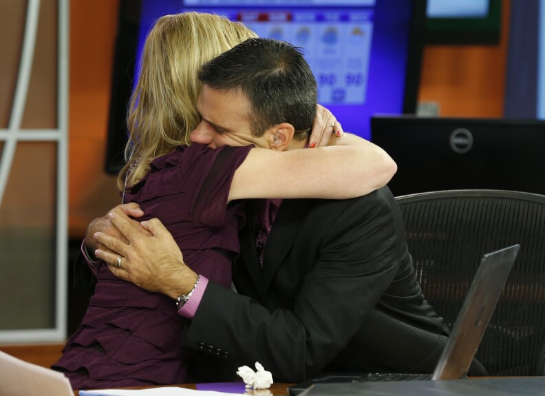 WDBJ-TV7 news morning anchor Kimberly McBroom, left, hugs meteorologist Leo Hirsbrunner after their early morning newscast at the station, Thursday, Aug. 27, 2015, in Roanoke, Va. Reporter Alison Parker and cameraman Adam Ward were killed during a live broadcast Wednesday, while on assignment in Moneta. (AP Photo/Steve Helber)