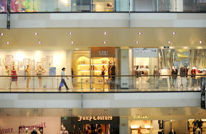 A shop employee (C) walks past boutiques at a shopping mall in Beijing on September 11, 2011. China on September 9 said its politically sensitive inflation rate softened in August, but analysts warned that price pressures would continue to trouble the government just as world demand slackens.    AFP PHOTO / LIU JIN (Photo credit should read LIU JIN/AFP/Getty Images)