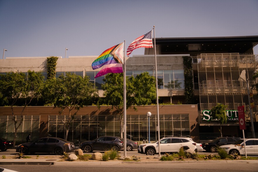 A progress LGBTQ+ pride flag hangs on a silver flagpole in West Hollywood.