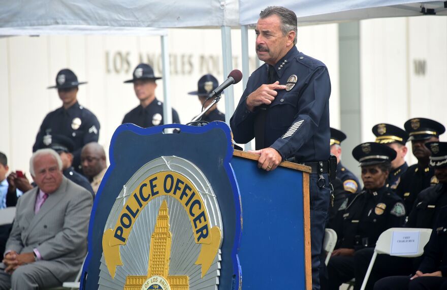 Los Angeles Police Chief Charlie Beck points to the black ribbon on his badge while addressing police recruits at their graduation ceremony on July 8, 2016 in Los Angeles, California as rappers Snoop Dogg and The Game led a peaceful demonstration outside in what they called an effort to promote unity in the aftermath of the deadly shootings of police officers in Dallas.

 / AFP / Frederic J. BROWN        (Photo credit should read FREDERIC J. BROWN/AFP/Getty Images)