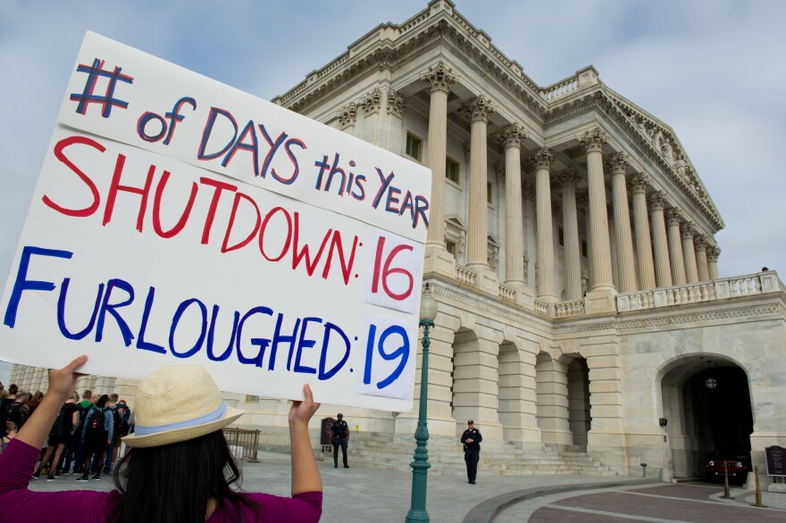 A furloughed government employee protests at the US Capitol October 16, 2013 in Washington, DC. US lawmakers embarked on another day of high-stakes political brinkmanship Wednesday, battling to scrape together an eleventh hour deal to protect Washington's battered financial standing.