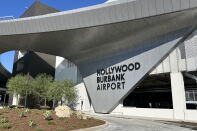 A wide view of the new Hollywood Burbank Airport sign that's connected to a large rounded overhang across the facility. 