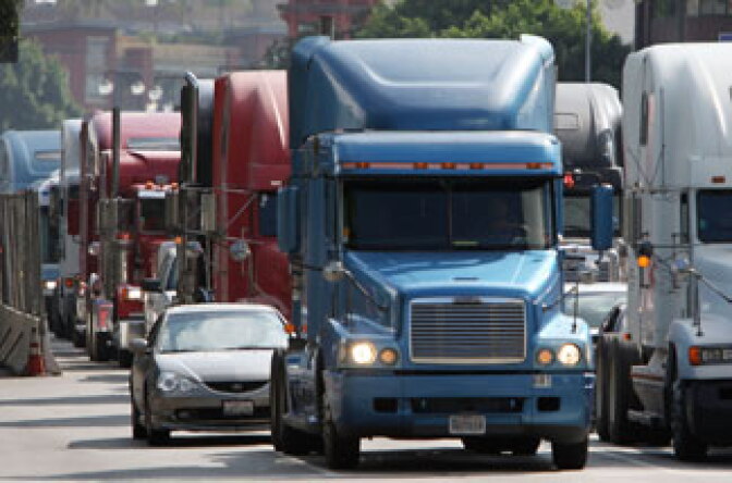 The EPA announced new standards Friday to reduce by 20 percent the maximum amount of soot released into the air from smokestacks, diesel trucks, buses and other sources. (Trucks drive near L.A. City Hall in protest over ports' Clean Truck Program in 2009).