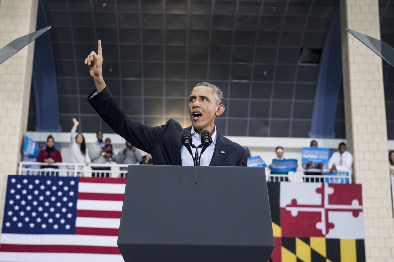 US President Barack Obama tries to stop people boing an immigration activist who interrupted him during a campaign event at Dr. Henry A. Wise Jr. High School October 19, 2014 in Upper Marlboro, Maryland.