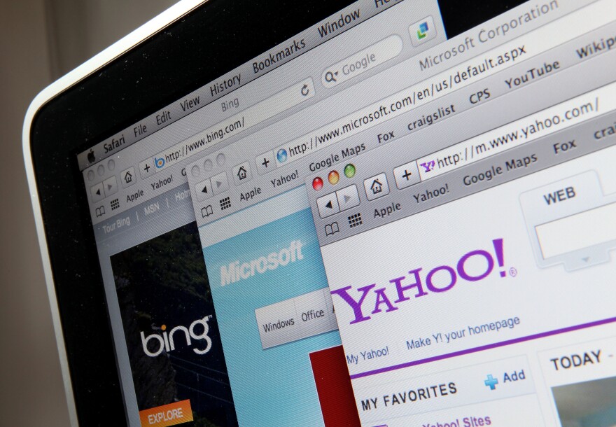 A close-up image of the corner of a laptop screen with several browsers open, each featuring a different website: Yahoo, Microsoft and Bing.