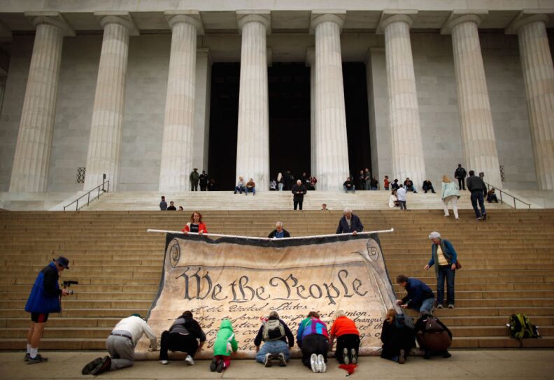 Volunteers help roll up a giant banner printed with the Preamble to the United States Constitution during a demonstration against the Supreme Court's Citizens United ruling.at the Lincoln Memorial on the National Mall October 20, 2010 in Washington, DC. The rally at the memorial was organized by brothers Laird and Robin Monahan who spent the last five months walking from San Francisco, California, to Washington to protest the court decision, which overturned the provision of the McCain-Feingold law barring corporations and unions from paying for political ads made independently of candidate campaigns.