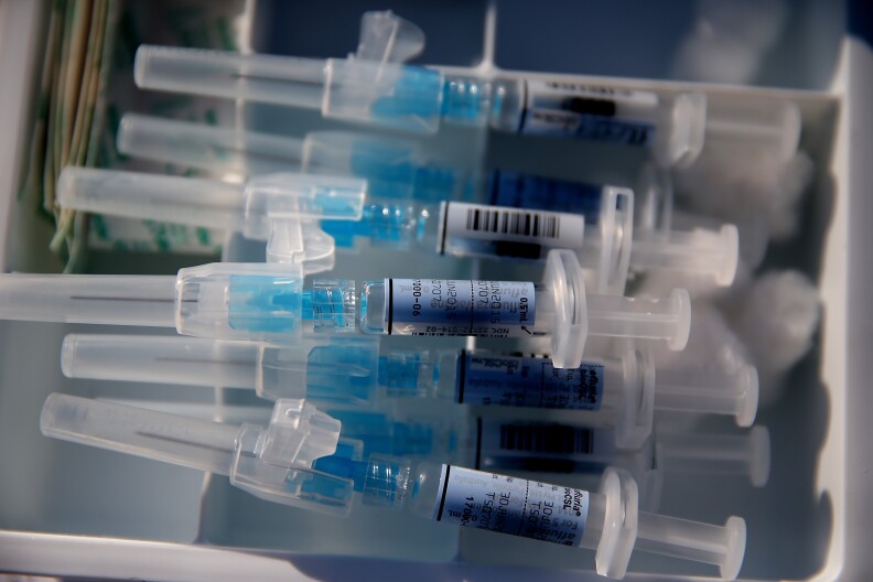 Syringes filled with flu vaccine sit on a table during a drive-thru flu shot clinic at Doctors Medical Center on November 6, 2014 in San Pablo, California. Doctors Medical Center hosted a drive-thru flu shot clinic offering free vaccines for any community member over the age of 18.