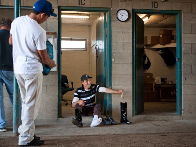 Exercise rider Joe Vacca takes off his riding boots for the day. Each rider takes out around six horses each morning.