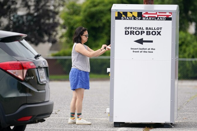 A woman drops a ballot into a drop box, casting her vote during Maryland's primary election, Tuesday, July 19, 2022, in Baltimore.  (Julio Cortez/AP)