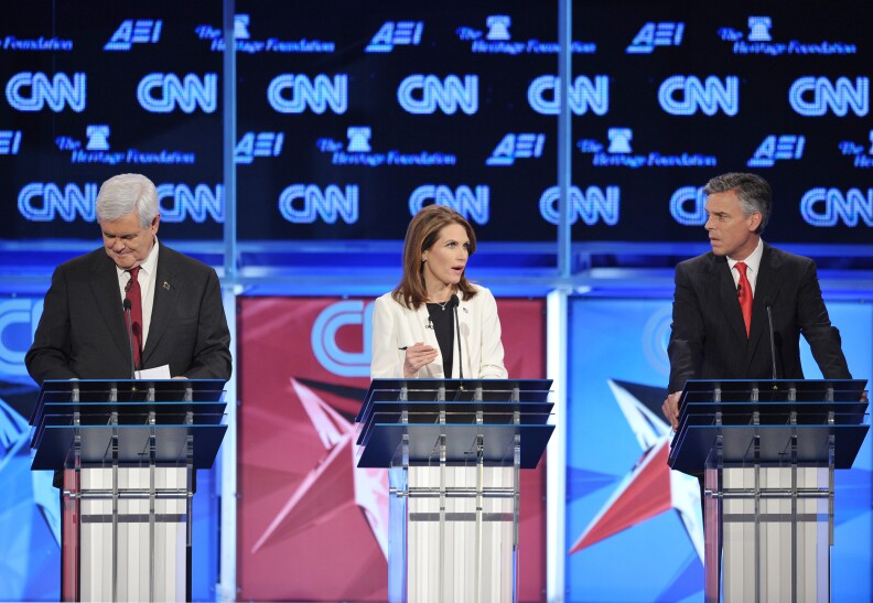 Minnesota Rep. Michele Bachmann (C) speaks as former Utah governor Jon Huntsman (R) and former house speaker Newt Gingrich (L) liten during the Republican presidential debate on national security November 22, 2011 at the Daughters of the American Revolution (DAR) Constitution Hall in Washington, DC. The debate is hosted by CNN in partnership with the Heritage Foundation and the American Enterprise Institute. AFP PHOTO / Mandel NGAN (Photo credit should read MANDEL NGAN/AFP/Getty Images)
