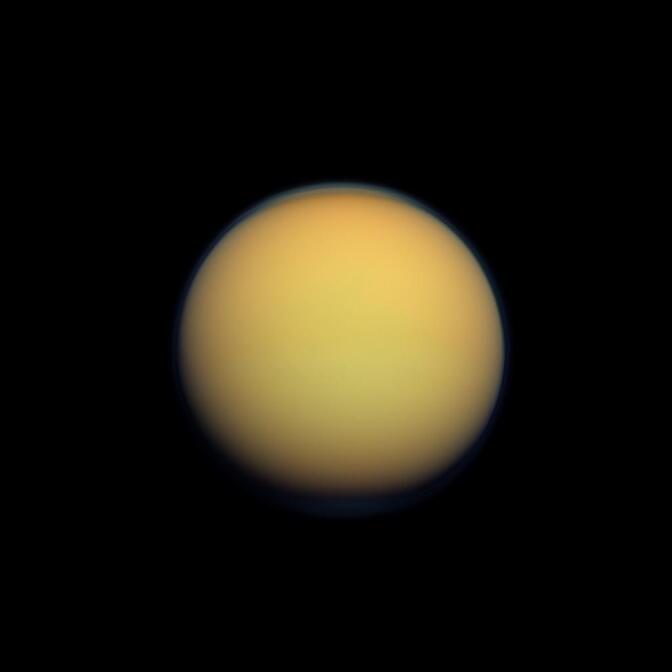 Titan's atmosphere makes Saturn's largest moon look like a fuzzy orange ball in this natural color view from the Cassini spacecraft.