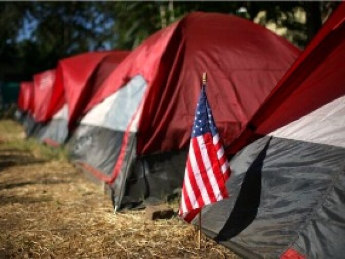 An American flag sits in front of a tent at an encampment in Sacramento, California.