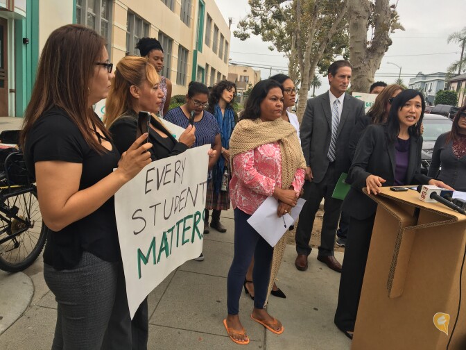 Long Beach Unified School District parents, activists and representatives of community groups look on as Public Advocates attorney Angelica Jongco addresses the media after the group decided to escalate its complaints against the school district.