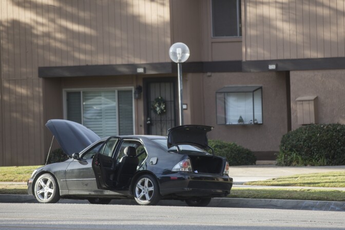 N Center Street between Pine Street and N Center Place remains closed as authorities continue to search a Redlands home on Thursday morning, Dec. 3, 2015 following Wednesday's mass shooting at in San Bernardino. The hood, doors and trunk of a car remain open outside the residence.