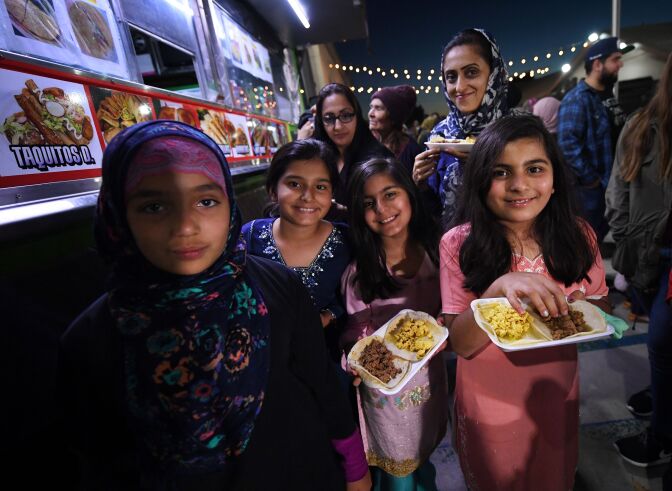 Muslim children break their Ramadan fast after sunset by eating halal Mexican tacos from a food truck, during a campaign called 'Taco Trucks at Every Mosqude' at the Islamic Center in Santa Ana, California on June 14, 2017.
