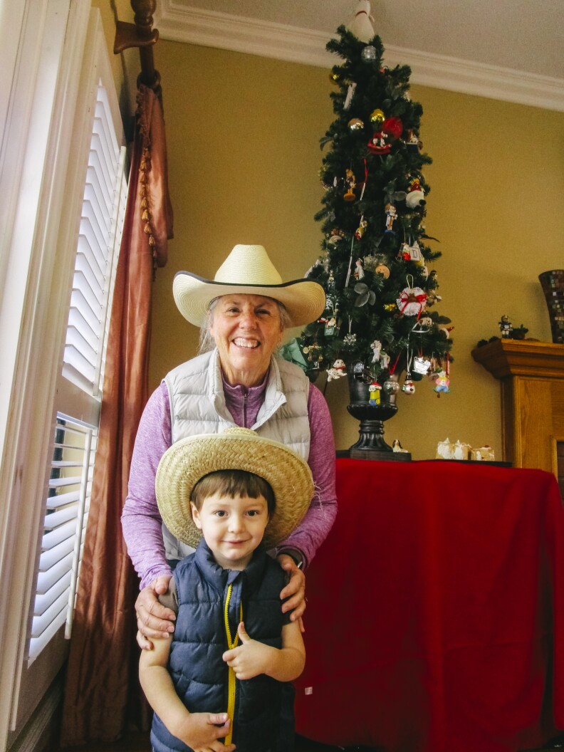 In this image, a woman and child pose next to a Christmas tree.