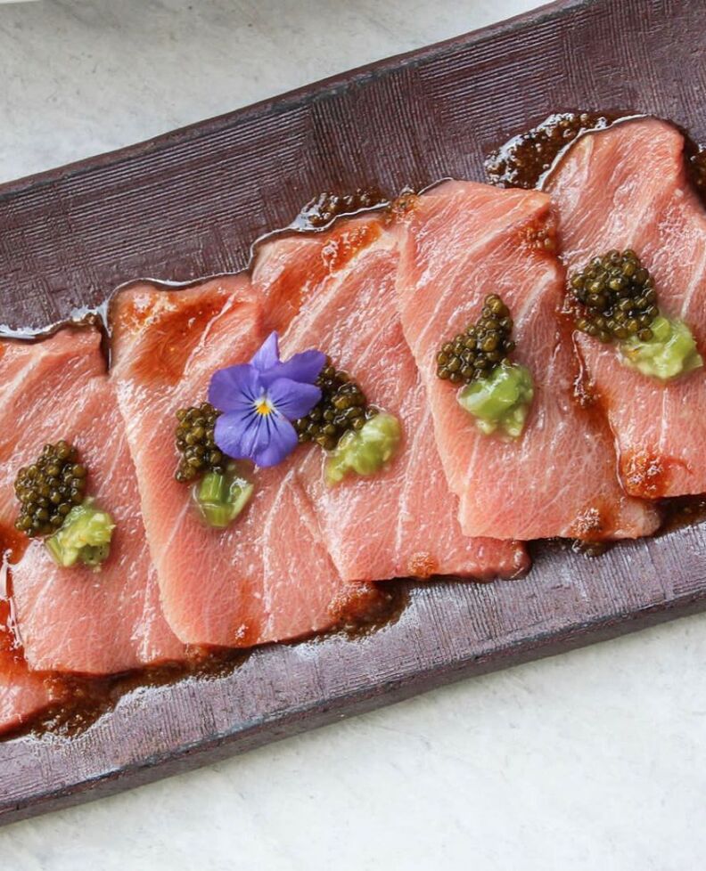 Slices of sashimi served on a clay slab. 