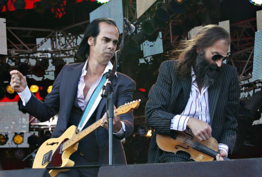 Australian singer Nick Cave (L) gestures during a performance with The Bad Seeds at the Roskilde festival in Roskilde on July 3, 2009.  