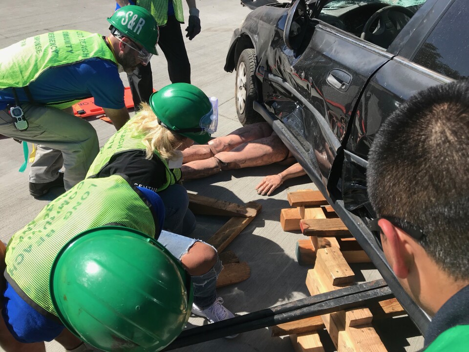 CERT trainees use crowbars and wooden blocks to lift a vehicle off a dummy victim. Photo credit: Audrey Alden