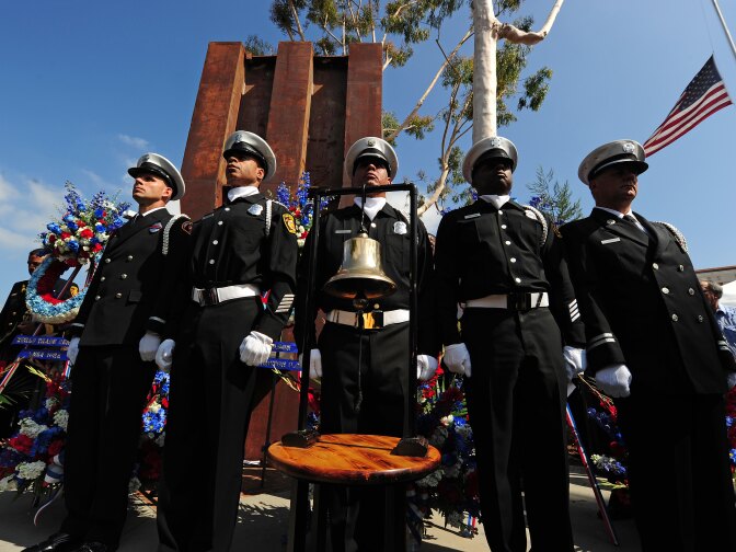 Members of the Los Angeles City Fire Department stand in front a 23-ton, 22-foot (6.7 meters) tall steel column that was a part of the lobby of the World Trade Center during  an official  9/11 Remembrance Ceremony for the tenth anniversary of the September 11, 2001 terrorist attacks on the United States, September 11, 2011 at the Frank Hotchkin Memorial Training Center  in Los Angeles, California. .  AFP PHOTO / ROBYN BECK (Photo credit should read ROBYN BECK/AFP/Getty Images)