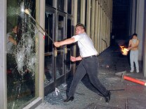 A rioter breaks a glass door of the Criminal Courts building, downtown Los Angeles, 29 April 1992, after a jury acquitted four police officers accused of beating a black youth, Rodney King, in 1991. Riots broke out throughout Los Angeles hours after the verdict was announced.        (Photo credit should read HAL GARB/AFP/Getty Images)