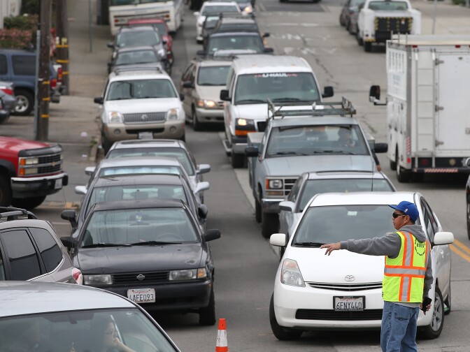 SAN FRANCISCO, CA - DECEMBER 10:  A San Francisco Department of Public works employee directs a line of cars waiting to enter the San Francisco DPW corporation yard to pick up free sandbags on December 10, 2014 in San Francisco, California. The San Francisco Bay Area is bracing for a severe storm that is expected to bring high winds and heavy rain that could topple trees and cause widespread flooding. Urban areas could see up to 6 inches of rain in less than 24 hours.  (Photo by Justin Sullivan/Getty Images)