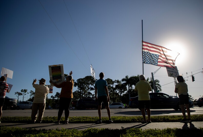 An upside-down U.S. flag has sunlight backlighting it.