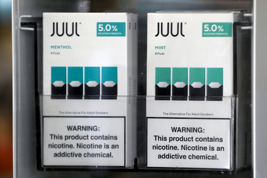 Packages of Juul mint-flavored e-cigarettes are displayed at a smoke shop in 2019.