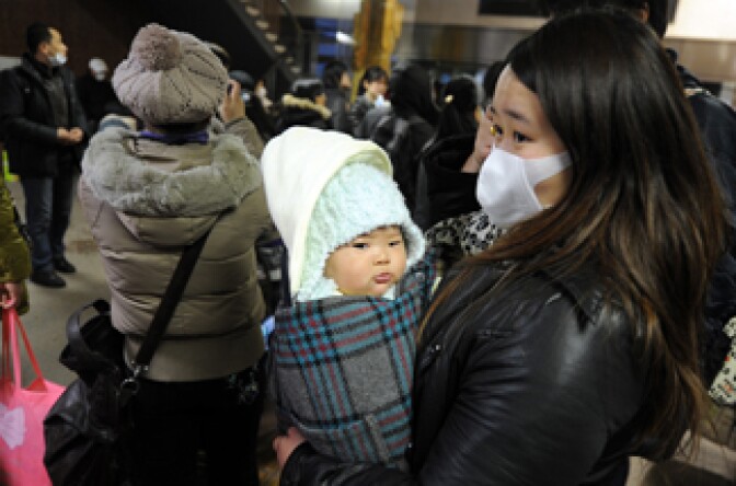 A group of Chinese citizens at the City Hall await transport to leave the tsunami devastated city of Sendai, Miyagi prefecture on March 15, 2011.